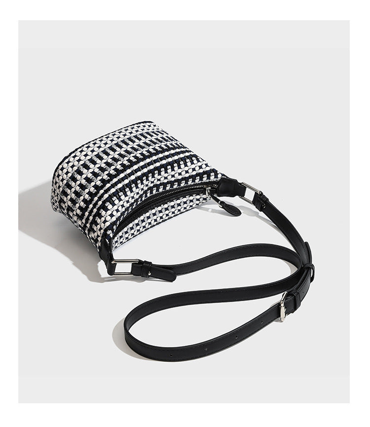 Small crescent shoulder bag in black-and-white woven textile with smooth black leather-look trim, zip-top closure, knotted