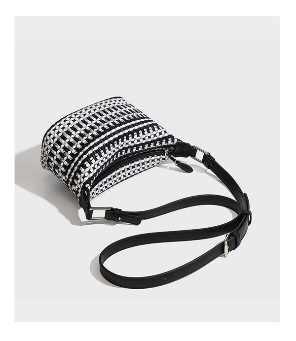 Small crescent shoulder bag in black-and-white woven textile with smooth black leather-look trim, zip-top closure, knotted