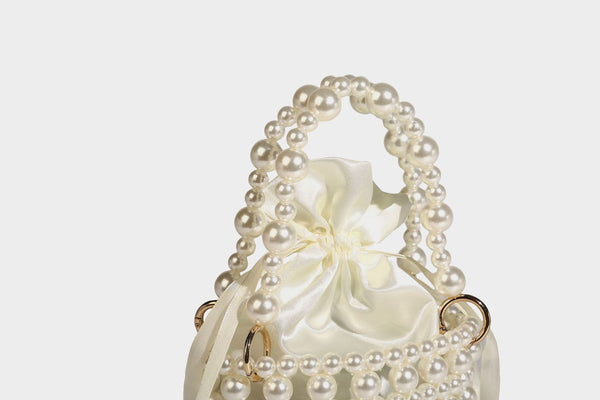 Elfenbeinfarbene Mini-Bucket-Bag aus Kunstperlen mit Satin-Innenbereich und Zugband, goldfarbenen Ringbeschlägen und gewölbtem Perlenhenkel an der Oberseite