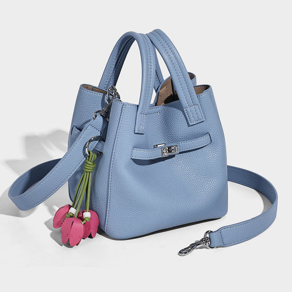 Small structured pebbled bucket tote bag with dual top handles, silver turn-lock front pocket, and detachable shoulder strap