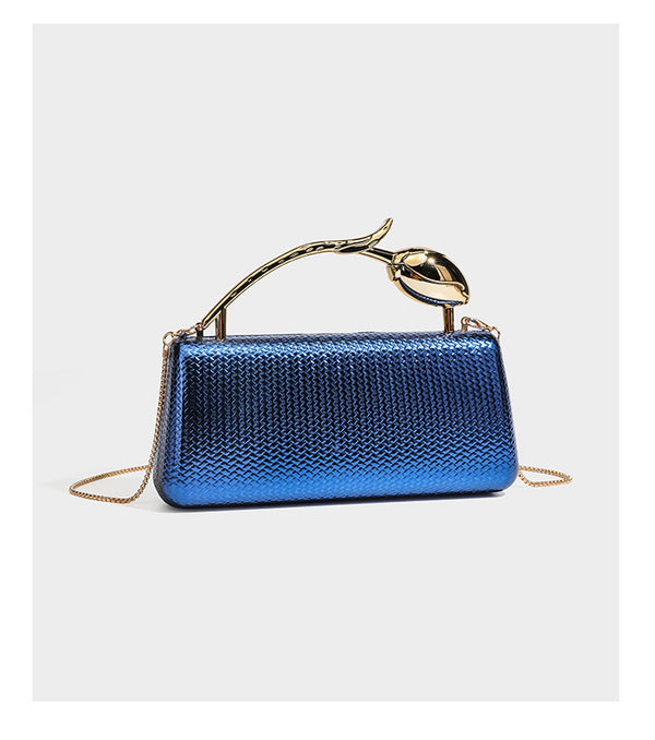Structured rectangular metallic woven clutch bag with sculptural gold-tone leaf top handle and detachable chain strap, detail