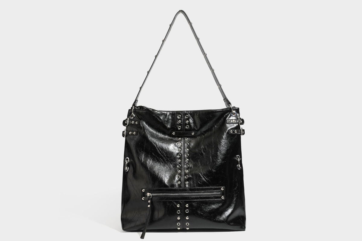 Black glossy leather-look slouchy shoulder bag with silver stud and eyelet hardware, top zip closure, front zip pocket, and