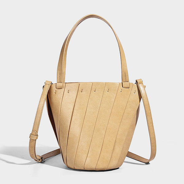 Structured bucket tote bag with vertical panel exterior, dual top handles, and detachable shoulder strap in tan leather-look