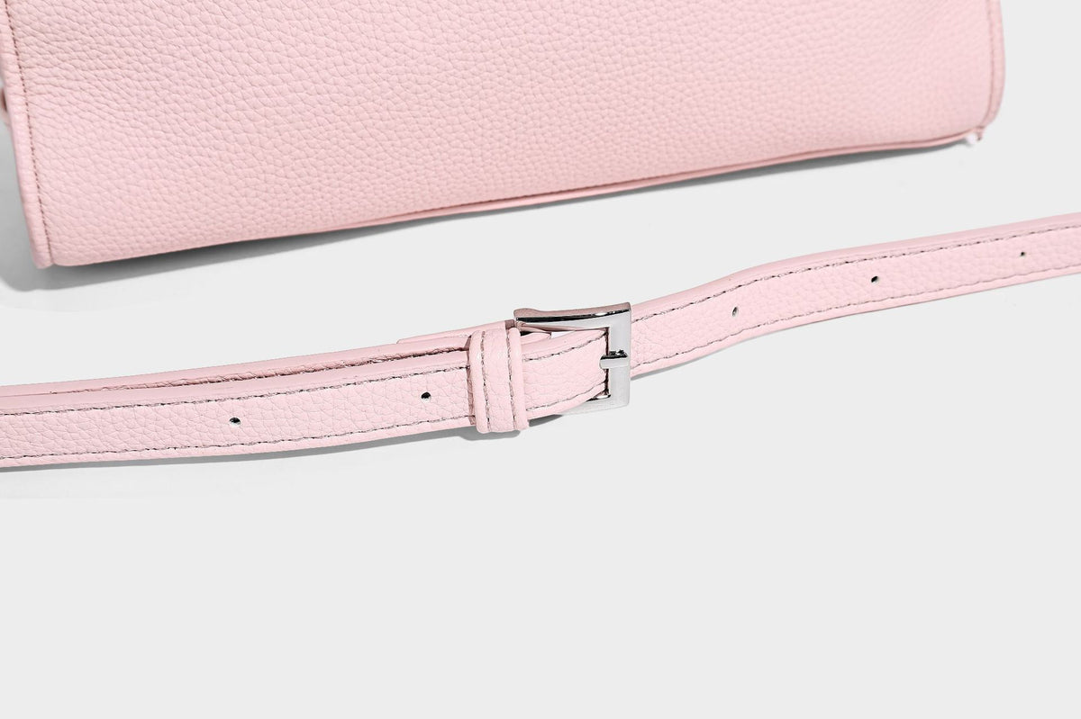 Small structured pebbled-finish shoulder bag with braided top handle, detachable crossbody strap, floral tassel charm, and