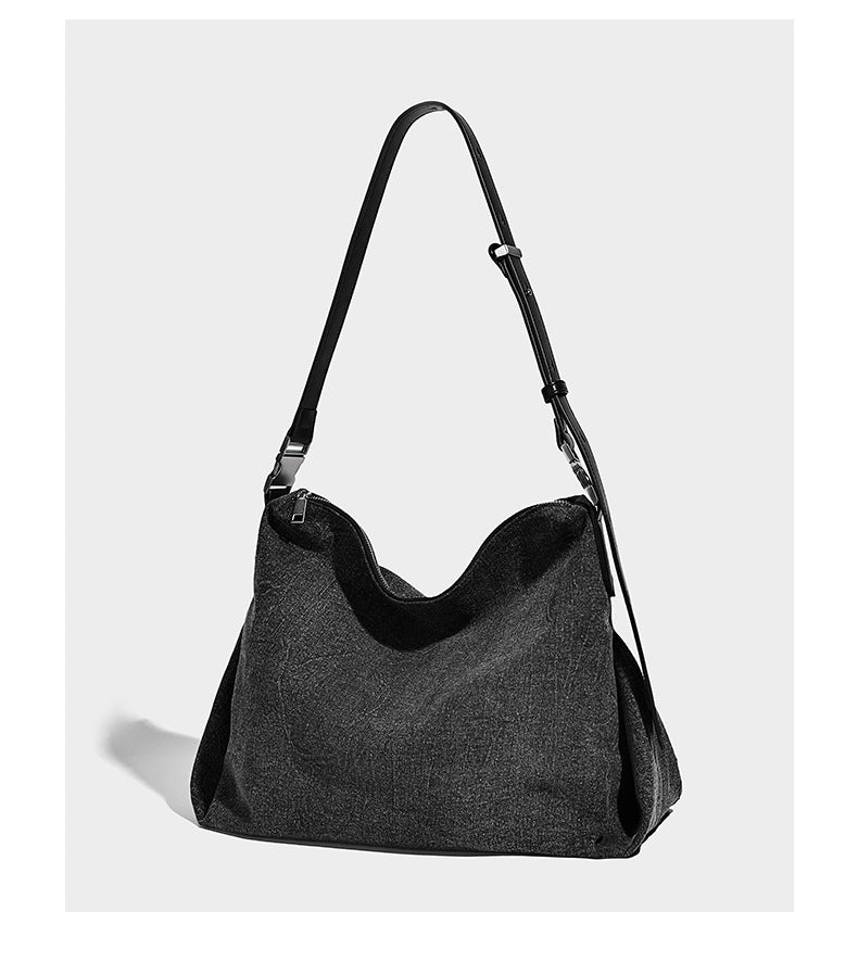 Charcoal denim-textured slouchy hobo bag with zip-top closure, silver-tone hardware, and adjustable leather-look crossbody