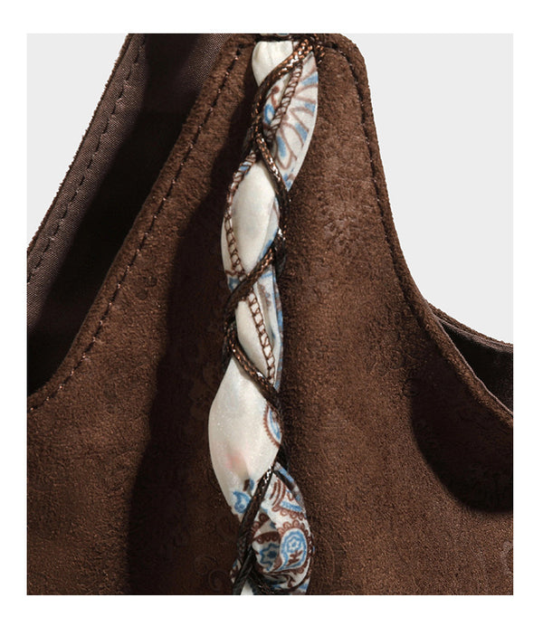 Slouchy paisley-embossed suede-look shoulder tote bag with braided patterned fabric straps and wood bead accents, detail view