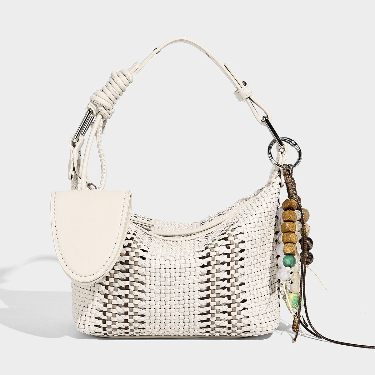 Small woven crescent shoulder bag with leather-look trim, zip closure, silver-tone ring hardware, and beaded tassel charm