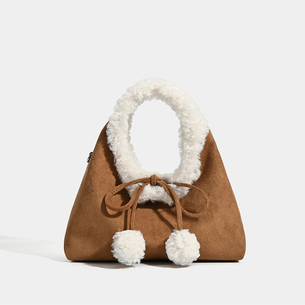 Trapezförmige Tasche aus karamellbraunem Wildlederimitat mit ovalem Henkel aus weißem Kunstfell, Pompon-Kordelverschluss und abnehmbarem Schulterriemen
