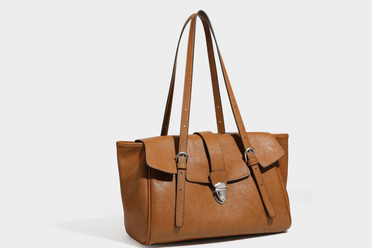 Large structured vintage-style tote bag with flap-front turn-lock closure, twin buckle straps, and double shoulder handles
