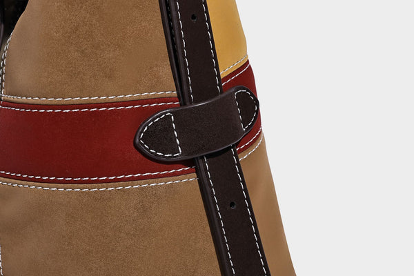 Patchwork bucket tote shoulder bag with tan, dark brown, olive, red, and sky blue color-block panels, white contrast, detail