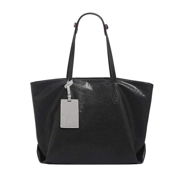 Oversized slouchy leather-look tote bag with long shoulder straps, contrast grey hanging tag, and silver-tone hardware