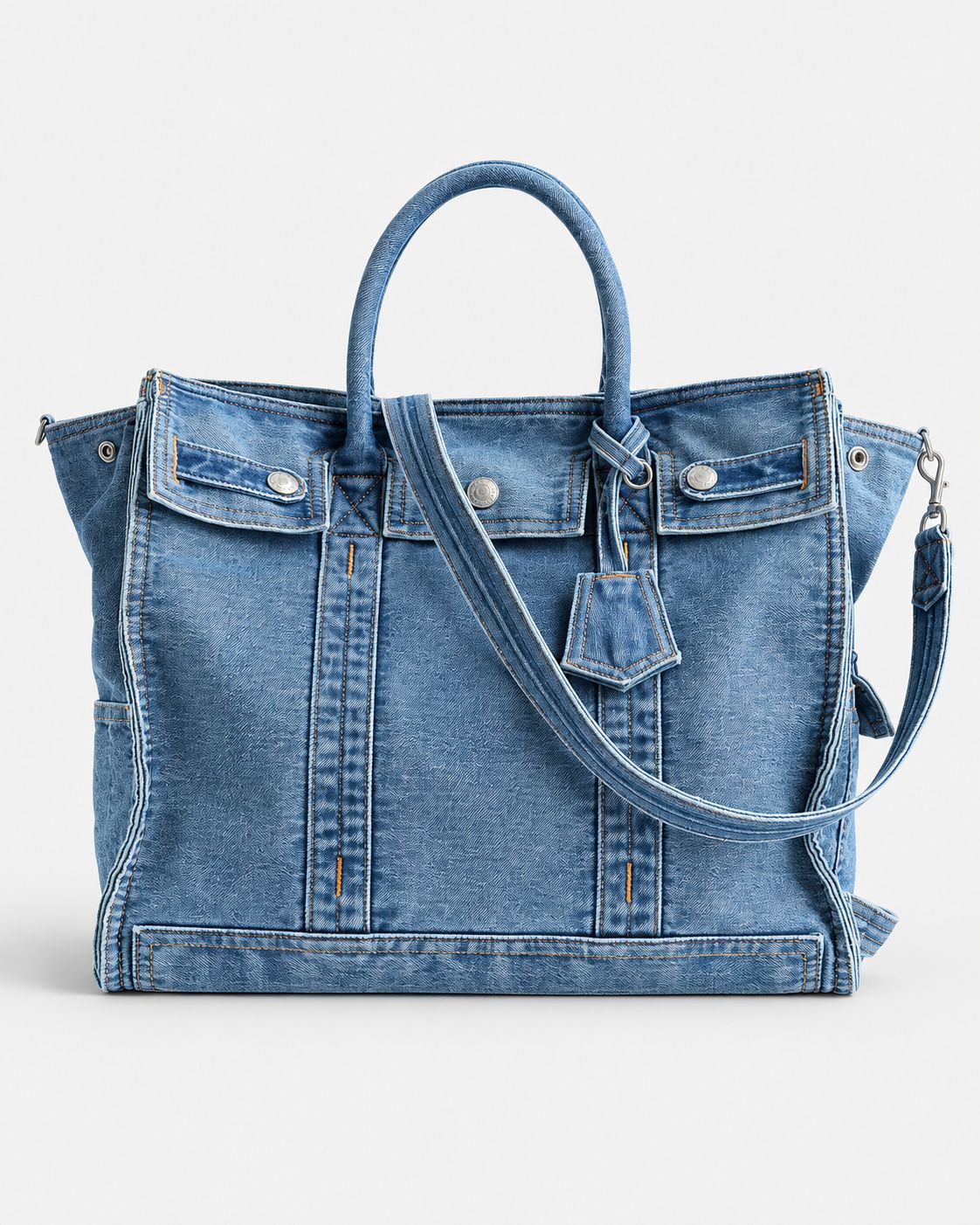 Large washed denim patchwork tote bag with snap-flap front pockets, rolled handles, and detachable shoulder strap, detail