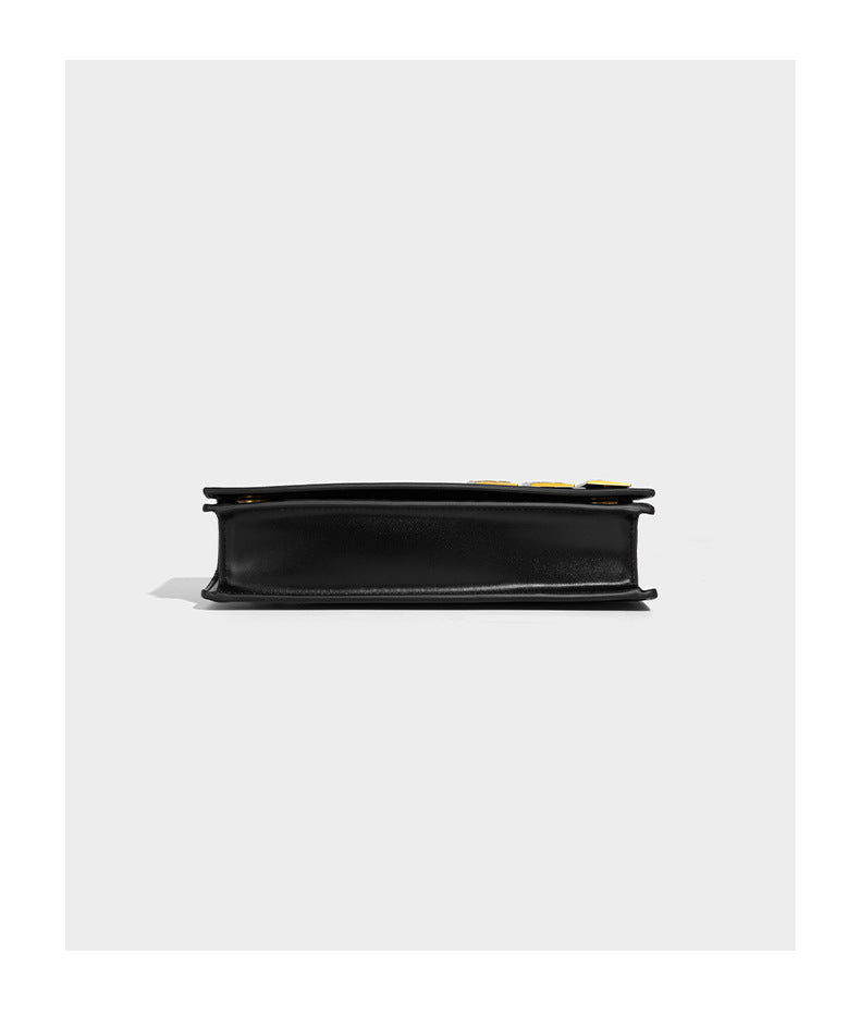 Structured rectangular crossbody bag with glossy finish, three vertical gold-tone embossed plaques, and gold chain strap