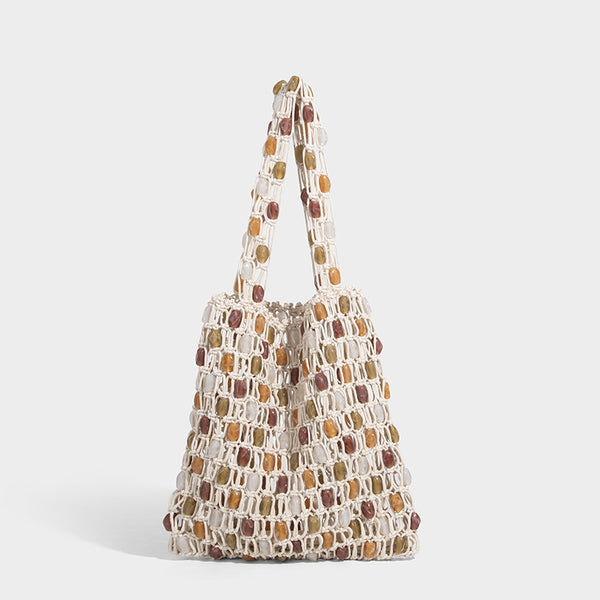 Cream macramé open-weave tote bag with multicolor amber olive and translucent bead accents and woven shoulder straps, detail
