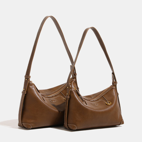 Smooth leather-look hobo bag with gold-tone ring hardware, contrast stitching, top handle and adjustable crossbody strap