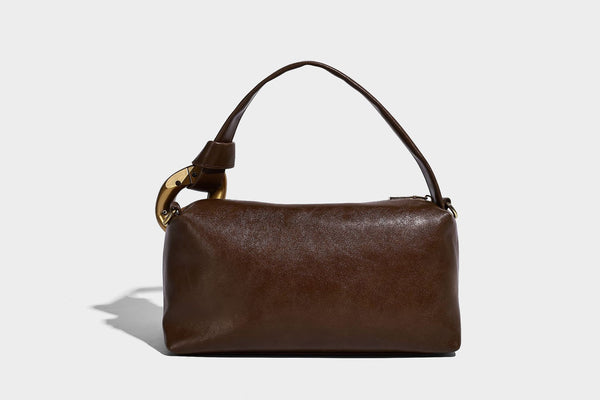 Kompakte Boston-Schultertasche in warmem Braun in Wildlederoptik mit glattem dunkelbraunem Besatz, übergroßen goldfarbenen Ringelementen und Reißverschluss oben