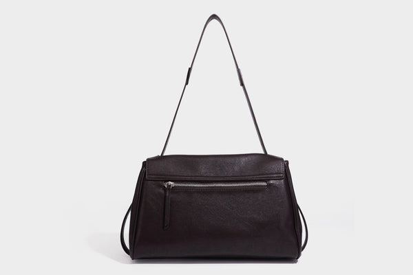 Strukturierte rechteckige dunkelbraune Schultertasche in Lederoptik mit Klappe, mehrlagigem Detail auf der Vorderseite und langem verstellbarem Riemen, Detailansicht