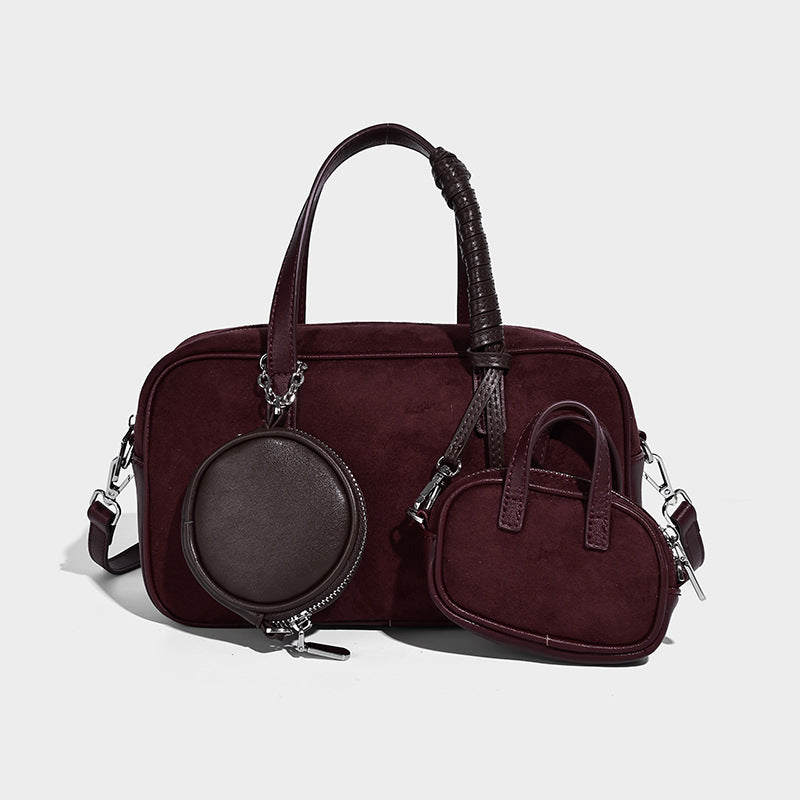 Strukturierte Boston-Bowlingtasche in Veloursleder-Optik, dunkelbraun, mit Henkeln mit blauen Akzenten und abnehmbarem Mini-Rundtäschchen, Detailaufnahme