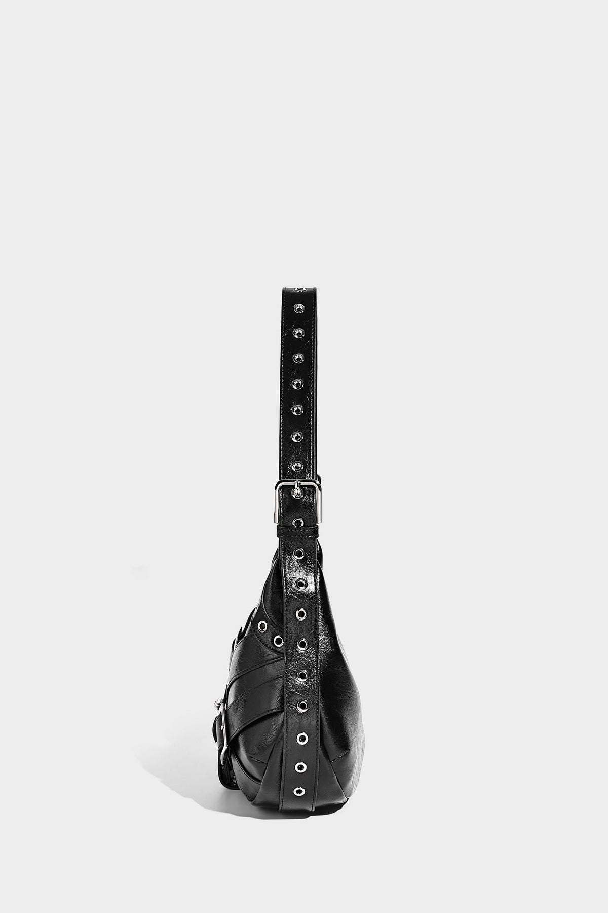 Glossy crescent hobo bag with silver-tone grommets, square buckle straps, and top zipper closure, detail view 18