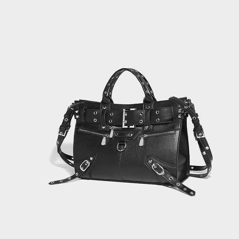 Black structured rectangular satchel bag with silver-tone rivets, large front buckle strap, zip pockets, dual top handles