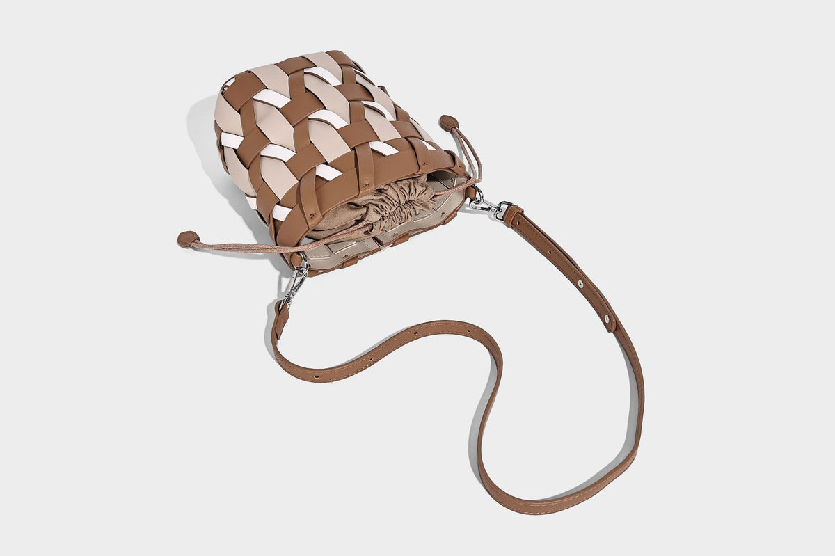 Small woven lattice bucket bag in tan and cream leather-look strips with drawstring top and detachable crossbody strap