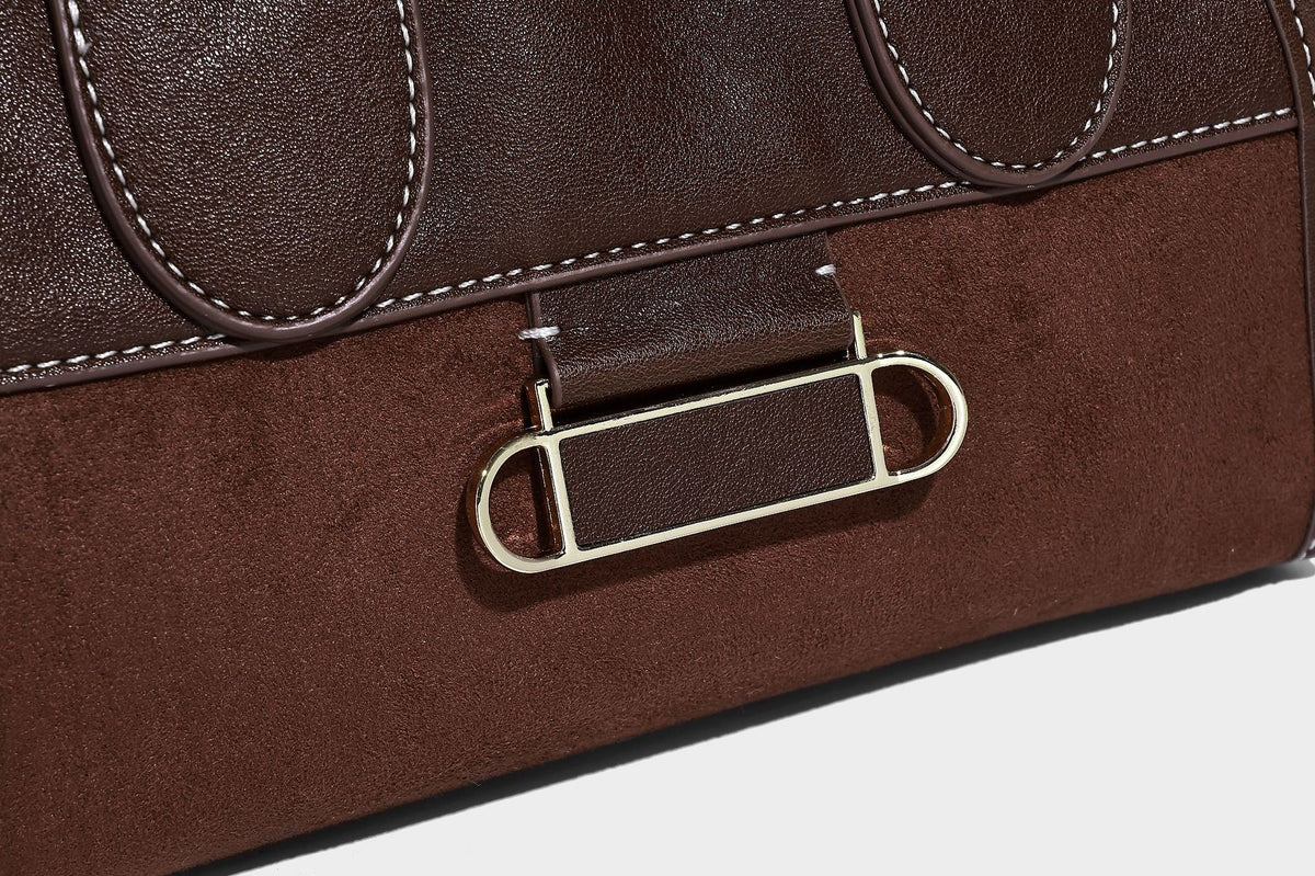 Kleine strukturierte Henkeltasche mit abgerundeten Tragegriffen, kontrastierenden weißen Steppnähten, Riegelverschluss in Silberoptik und abnehmbarem