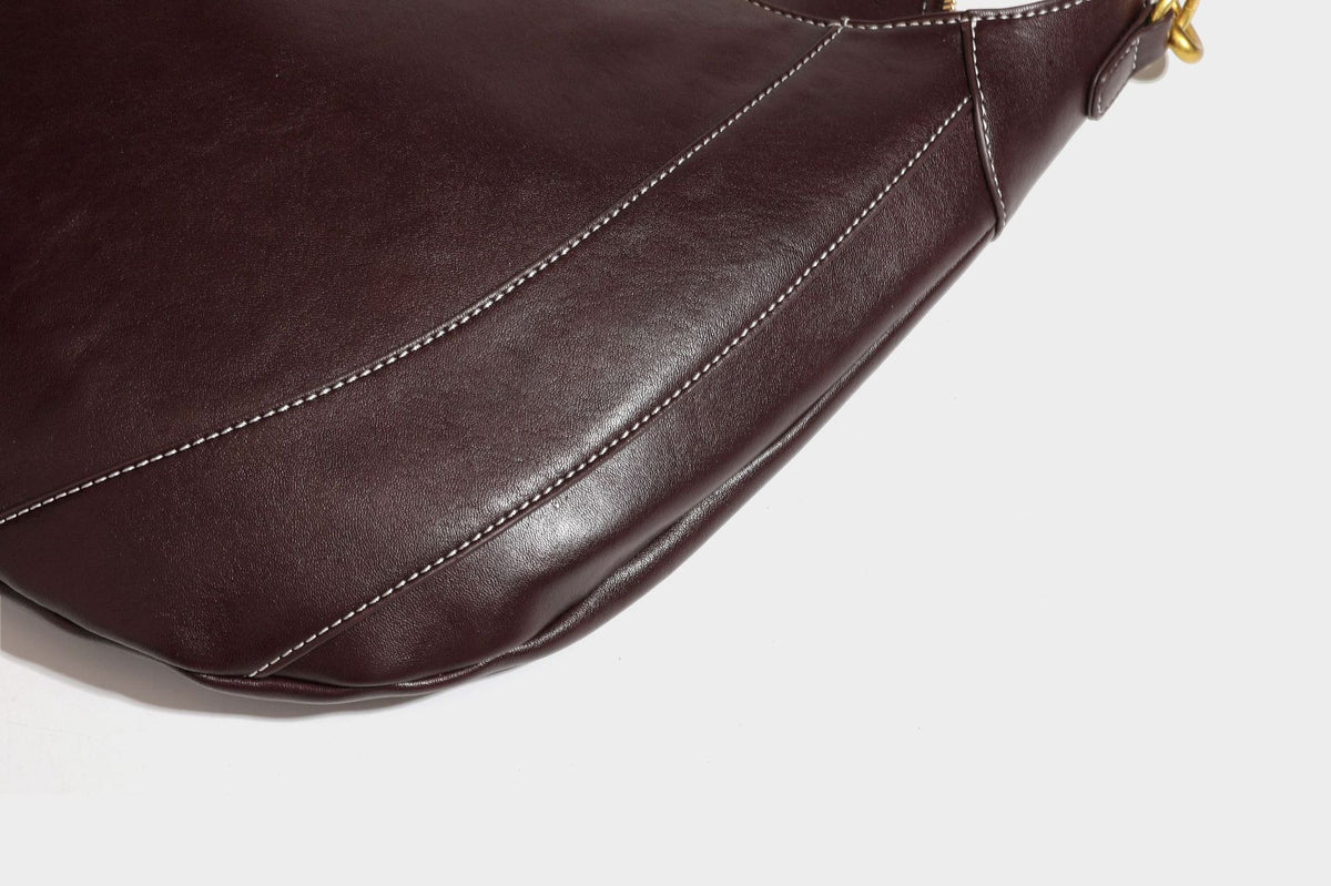 Lässige halbmondförmige Hobo-Schultertasche in Dunkelbraun mit goldfarbenem Ring und Kettenglied-Beschlägen sowie Reißverschluss oben, Detailansicht