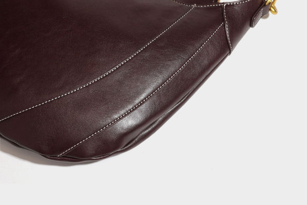 Lässige halbmondförmige Hobo-Schultertasche in Dunkelbraun mit goldfarbenem Ring und Kettenglied-Beschlägen sowie Reißverschluss oben, Detailansicht
