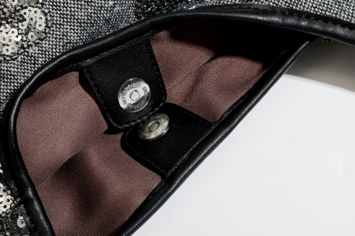 Lässig fallende, trapezförmige Schulter-Tote in Anthrazitgrau mit floralen Paillettenmotiven in Silber, Riemen in Lederoptik und herabhängendem Perlenbesatz