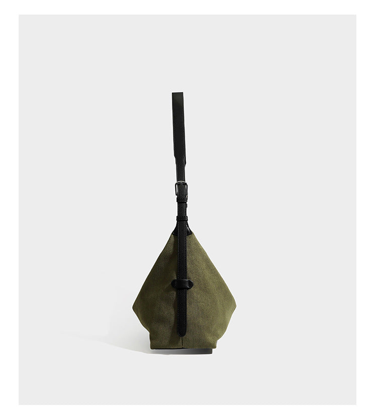 Slouchy olive green canvas hobo shoulder bag with black leather-look trim, zip-top closure, and adjustable strap, detail view
