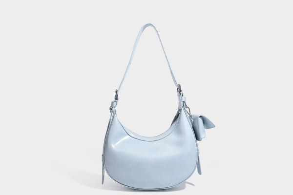 Glossy leather-look crescent hobo shoulder bag with dark contrast trim, silver-tone hardware, and attached mini flap pouch