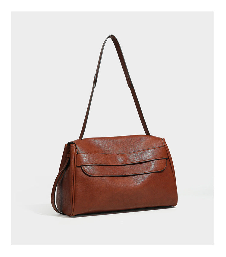 Structured rectangular flap shoulder bag in dark brown leather-look finish with long single strap and layered front panel