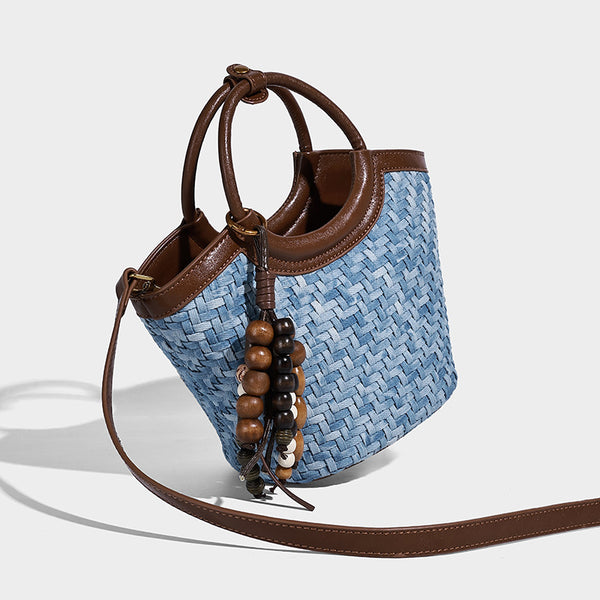 Blaue Bucket Bag in gewebter Denim-Optik mit brauner Besatz in Lederoptik, rundem Tragegriff, Quaste mit Holzperlen und verstellbar