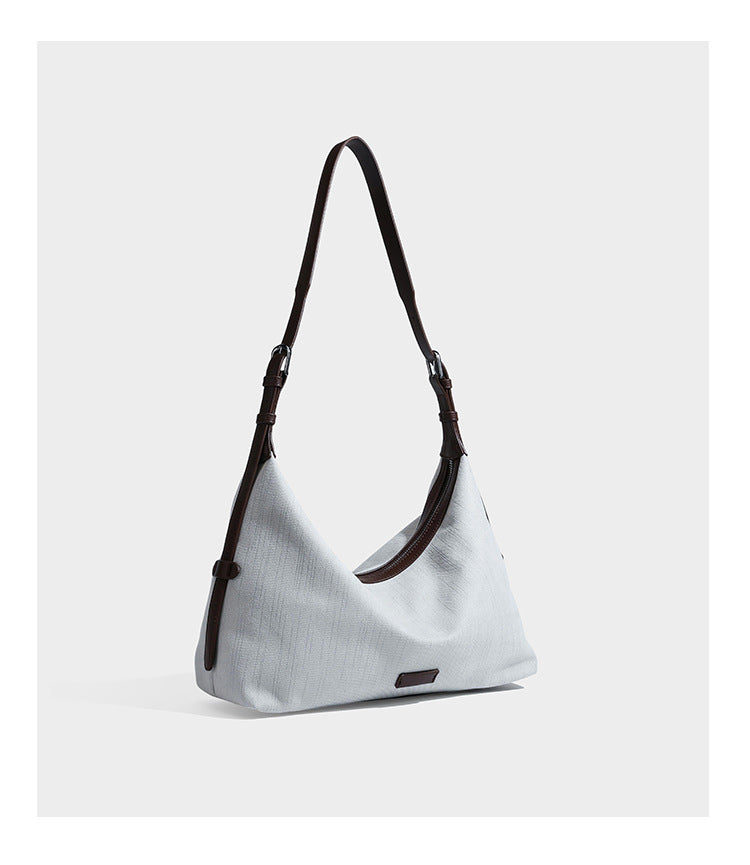 Slouchy olive green canvas hobo shoulder bag with black leather-look trim, zip-top closure, and adjustable strap, detail view