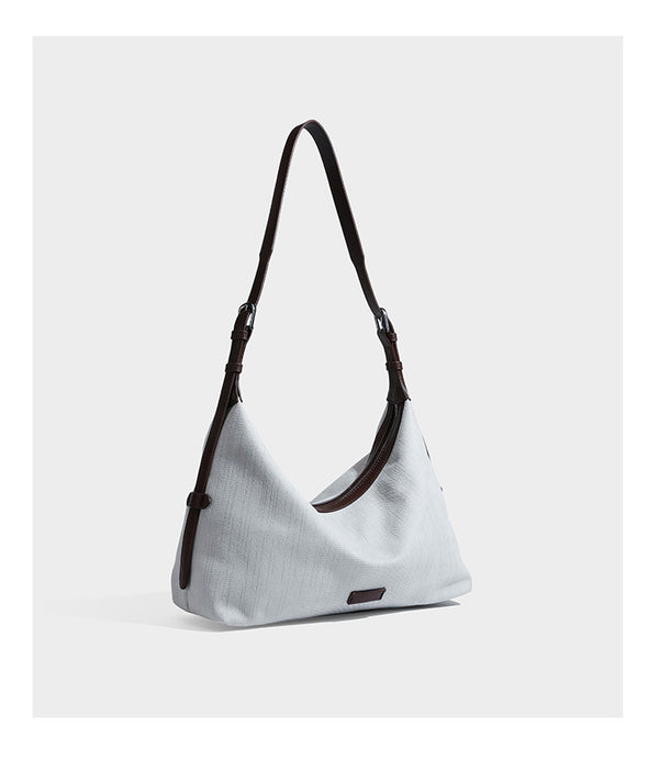 Slouchy olive green canvas hobo shoulder bag with black leather-look trim, zip-top closure, and adjustable strap, detail view