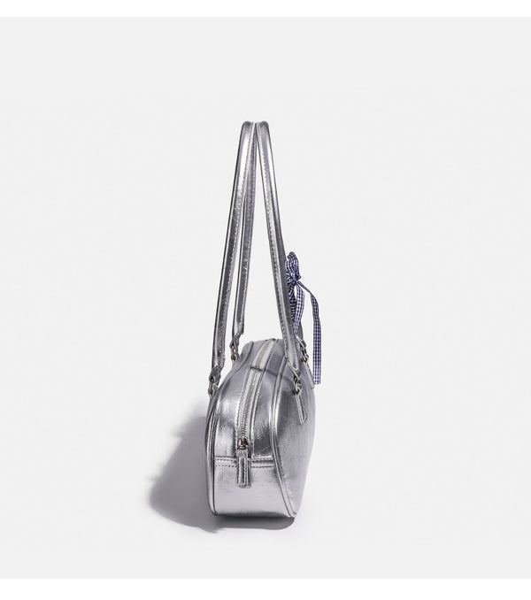 Rounded rectangular shoulder bag with glossy crinkled finish, dual long handles, top zip closure, and gingham ribbon bow