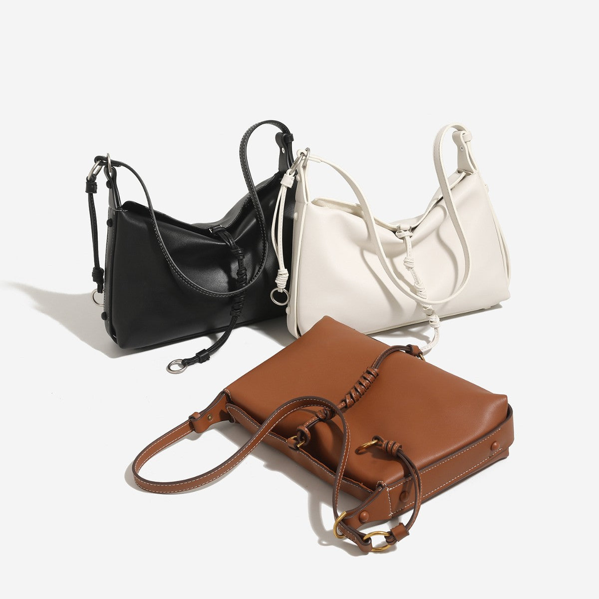 Slouchy crescent hobo bag in smooth matte leather-look finish with knotted cord base detail and antique gold-tone ring, front