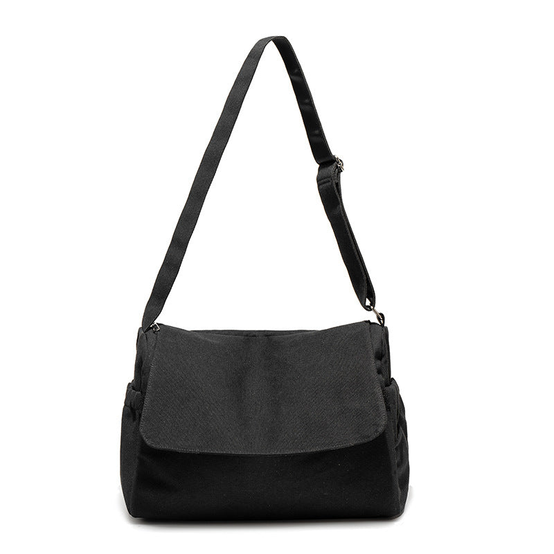 Große Messenger-Bag aus mattem schwarzem Canvas mit Frontklappe, Reißverschluss oben, elastischen Seitentaschen und verstellbarem silberfarbenem