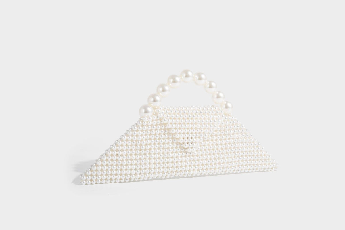 Small structured triangle clutch bag covered in glossy pearl beads with an arched pearl top handle and silver snap closure