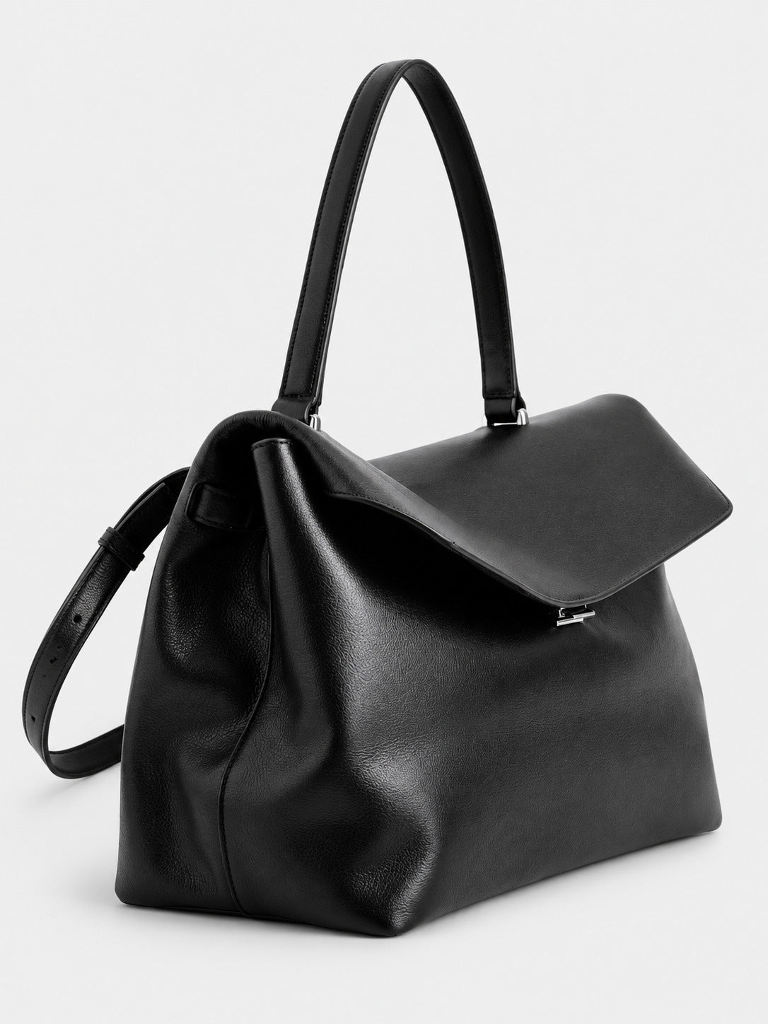 Large black slouchy leather-look shoulder bag with V-shaped envelope flap, silver-tone clasp, and adjustable strap, detail