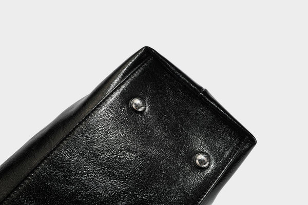 Glänzende schwarze, weich fallende Schultertasche mit gerafftem Abschluss, zwei langen Trageriemen, silberfarbenen Beschlägen und abnehmbarem Umhängeriemen
