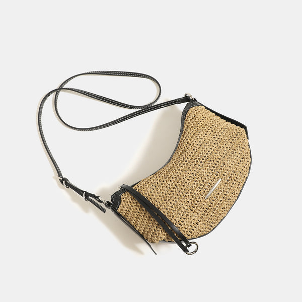 Compact crescent-shaped woven straw crossbody bag with black leather-look trim, top zip closure, and adjustable shoulder