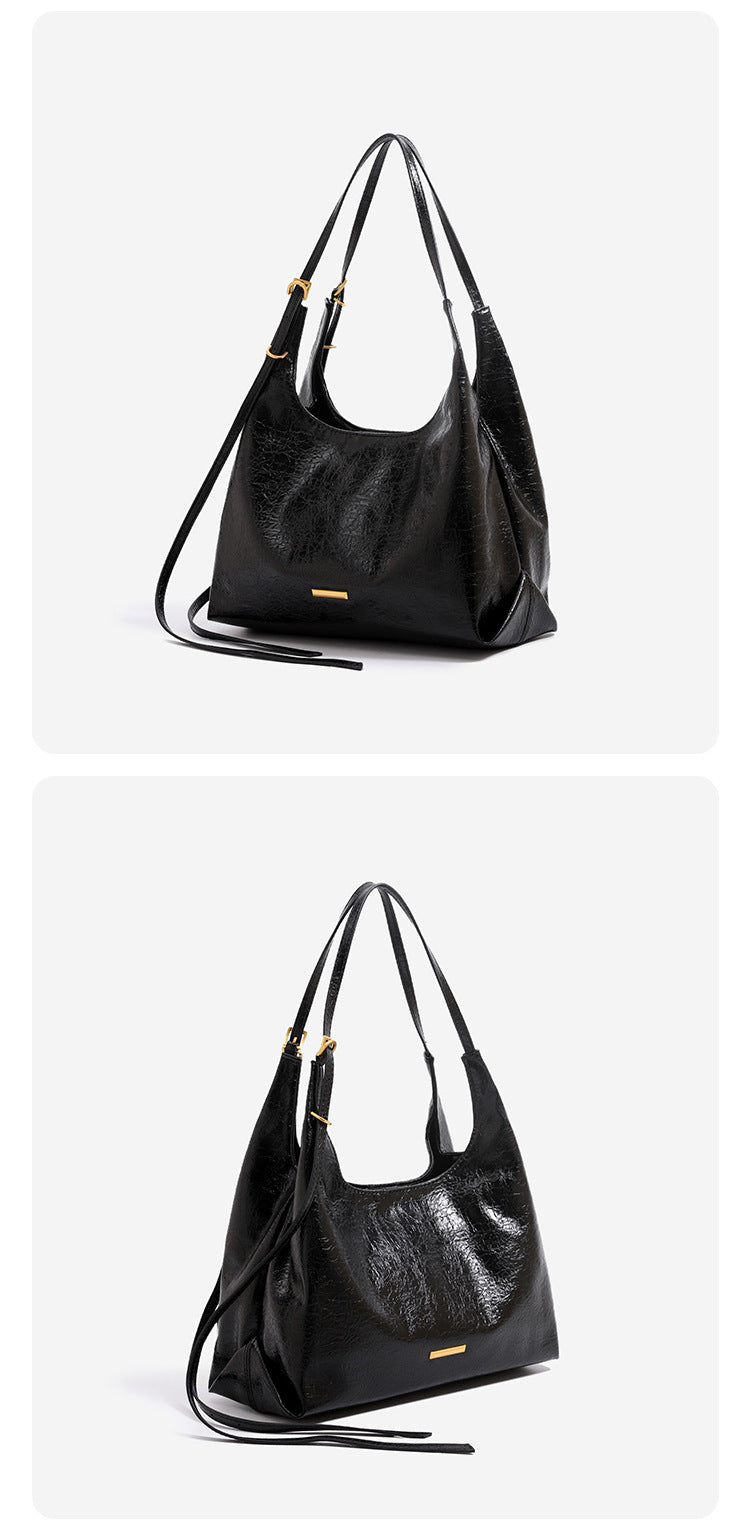 Slouchy hobo shoulder bag in crinkle high-gloss leather-look finish with gold-tone bar hardware and adjustable strap, detail