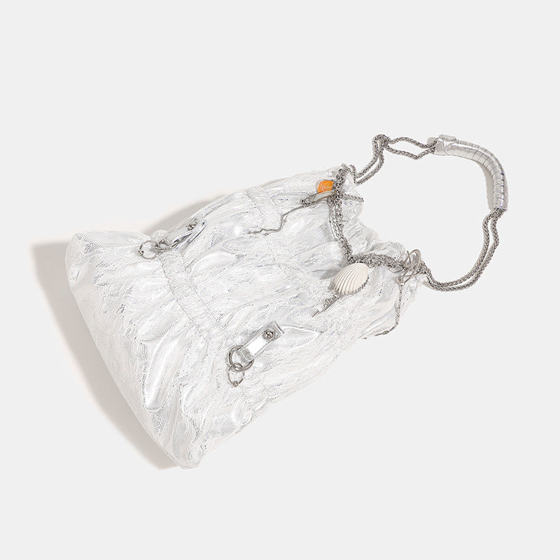 Slouchy lace-texture bucket bag with silver-tone chain strap, draped chain hardware, and shell charms, detail view 3