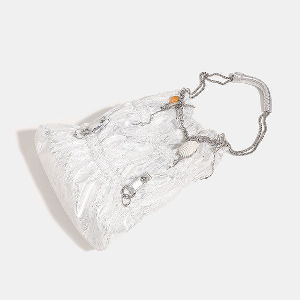 Slouchy lace-texture bucket bag with silver-tone chain strap, draped chain hardware, and shell charms, detail view 3