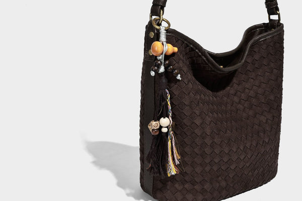 Dark chocolate woven texture hobo shoulder bag with multicolor tassel-and-bead charm and long adjustable strap, detail view