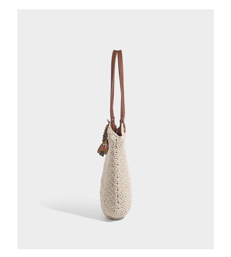 Woven crochet open-top shoulder tote bag with slim brown leather-look straps and braided charm accent, detail view 12