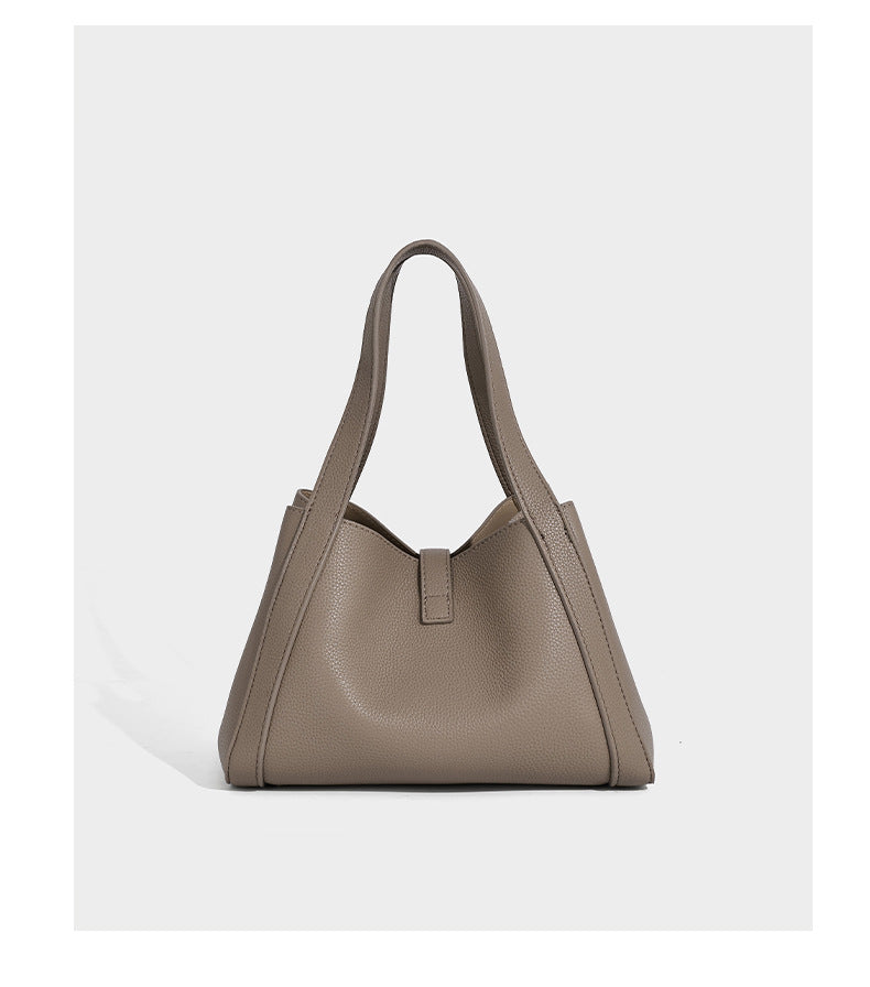 Structured trapezoid tote bag in taupe pebbled leather-look finish with gold-tone turn-lock hardware, dual top handles, and