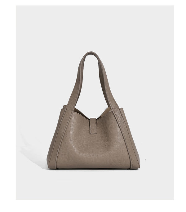 Structured trapezoid tote bag in taupe pebbled leather-look finish with gold-tone turn-lock hardware, dual top handles, and