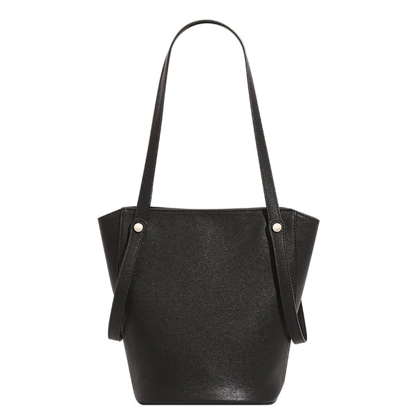 Structured black leather-look bucket tote bag with slim shoulder straps, silver-tone stud hardware, and tapered body, detail